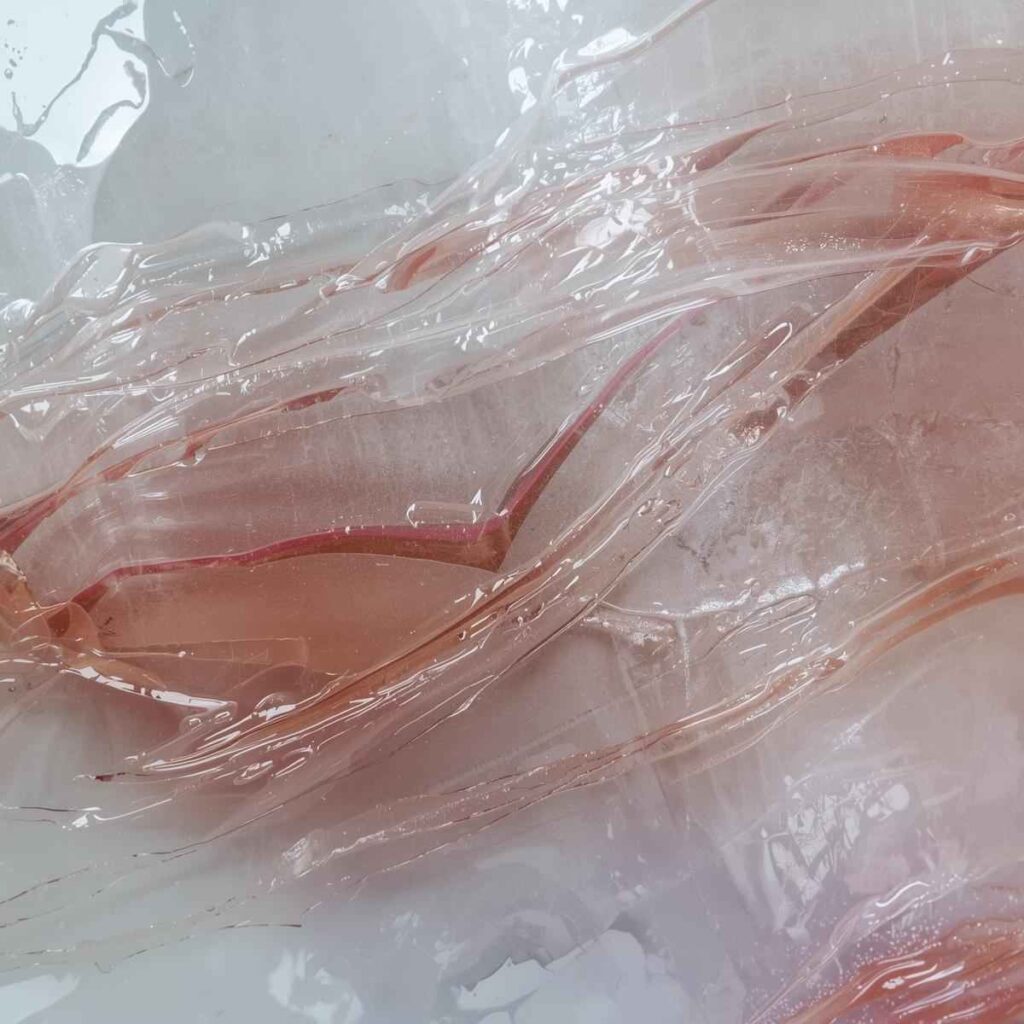 A close-up of abstract wall art with several thin, self-leveling layers of clear pour coat, demonstrating deep, resin-like shine.